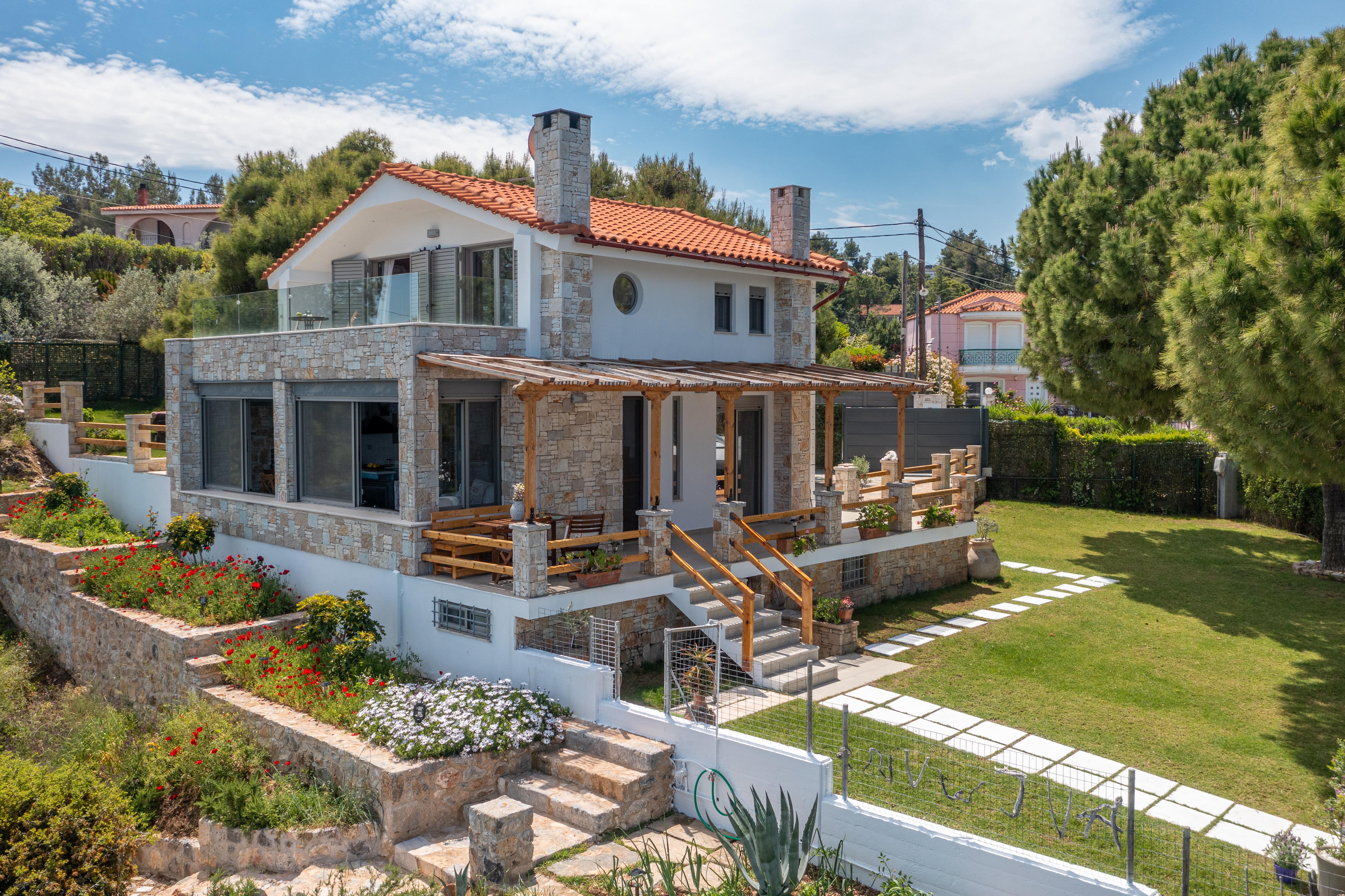 Crystal Beach Villa exterior with modern design and lush garden, offering panoramic sea views.